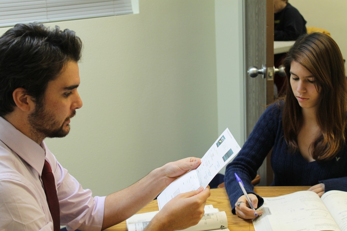 Tutor and student reviewing written work together